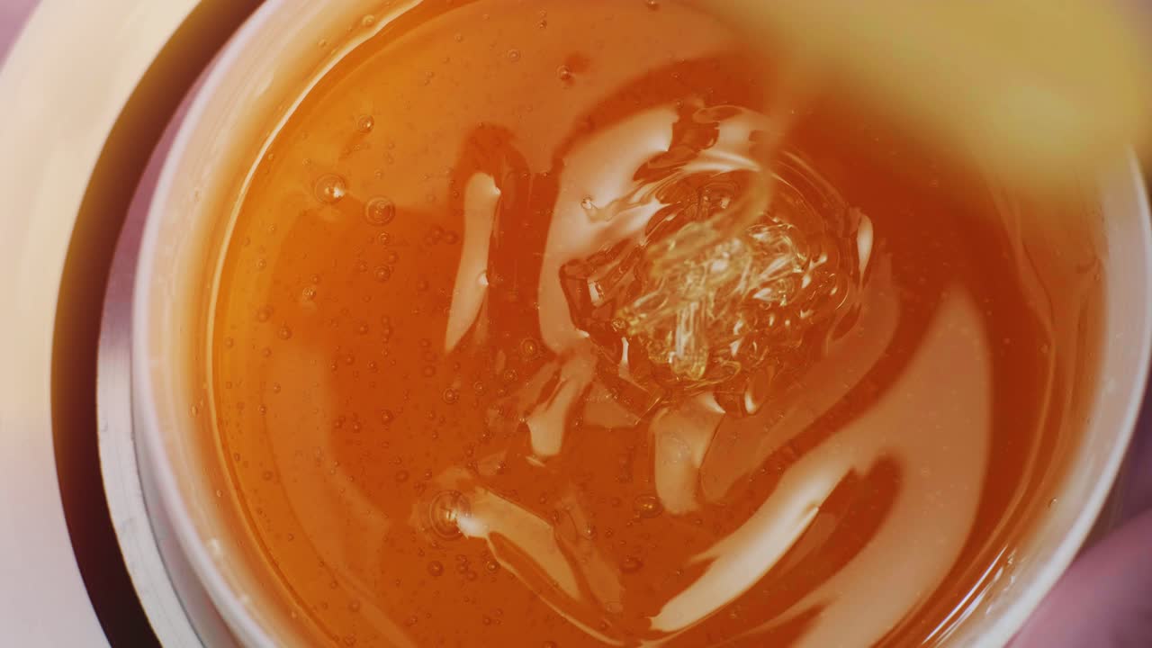 Liquid sugar for skin epilation. Close up shot. depilation and beauty concept - sugar paste or wax honey for hair removing with wooden waxing spatula sticks