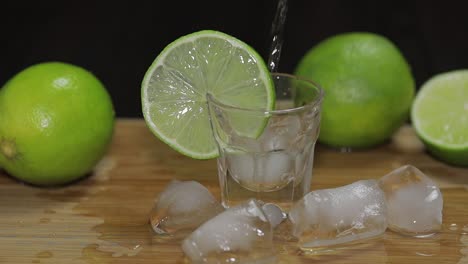 verter vodka o tequila en vasos con cubitos de hielo