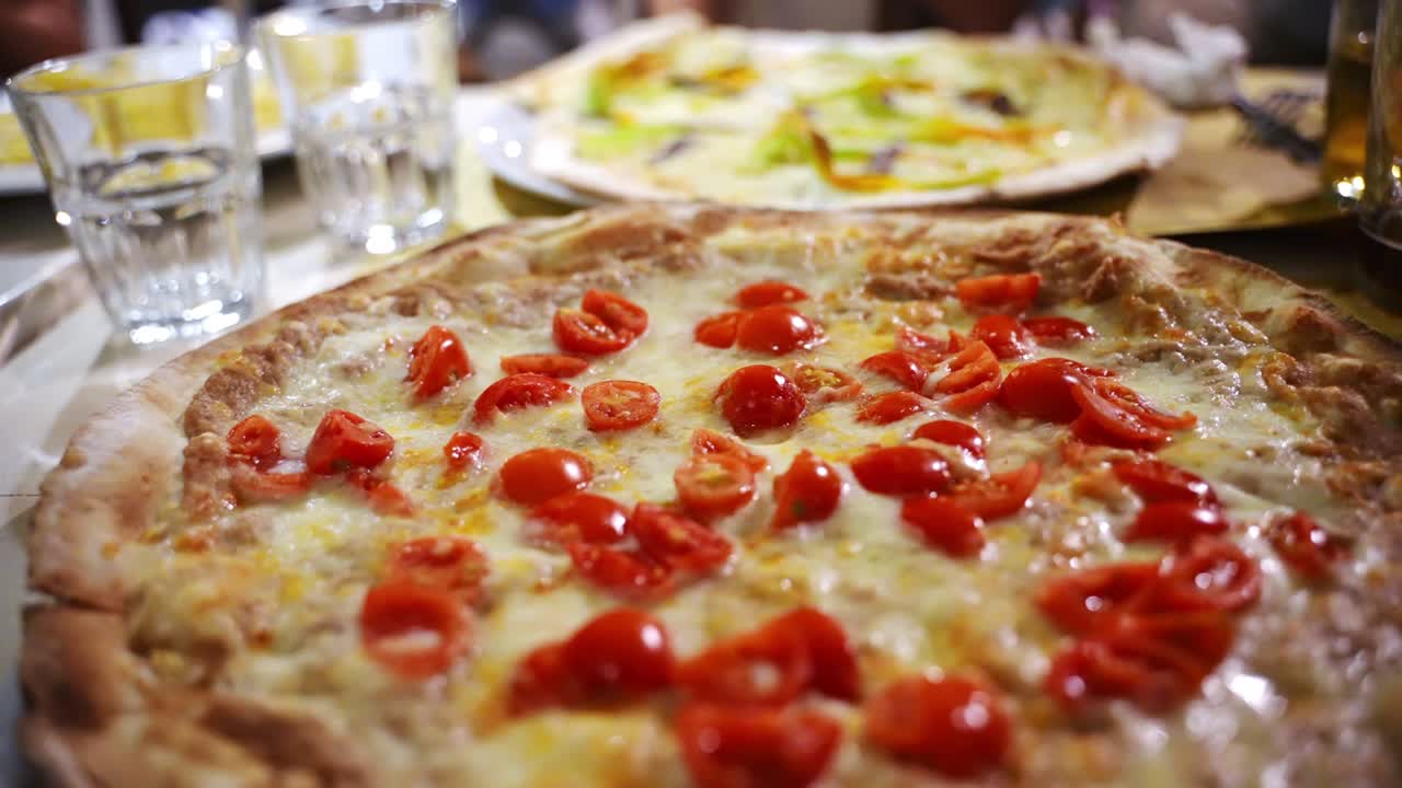 독점적인 이탈리아 피자를 가진 전통적인 지역 레스토랑, 손님을위한 다양한 맛있는 피자를 가진 접시, 은 토마토, 고추 및 녹은 치즈, 채식주의자 zucchini 피자를 배경으로 맛있는 뜨거운 피자의 클로즈업, 지중해 피자 메뉴