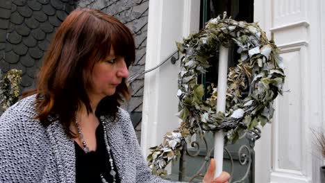 a woman decorates her shop window for the christmas season