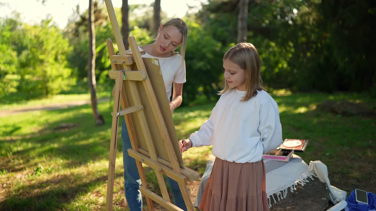 Mère et fille peignant en plein air