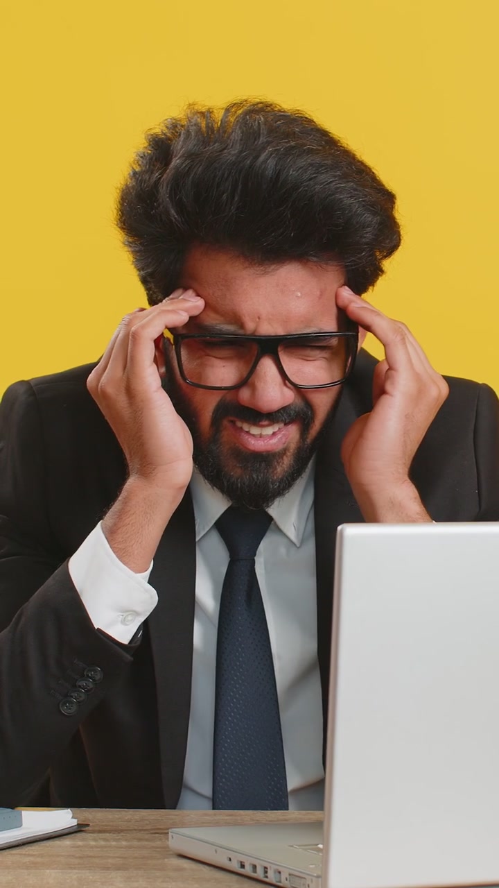 Tired indian business man suffering from headache problem tension migraine stress at home office