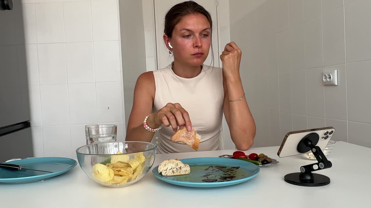 Giovane donna che mangia pane intinto nell'olio d'oliva a casa