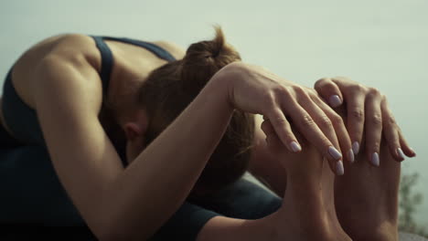 relaxed sportswoman bending back sitting yoga pose. girl practicing gymnastic