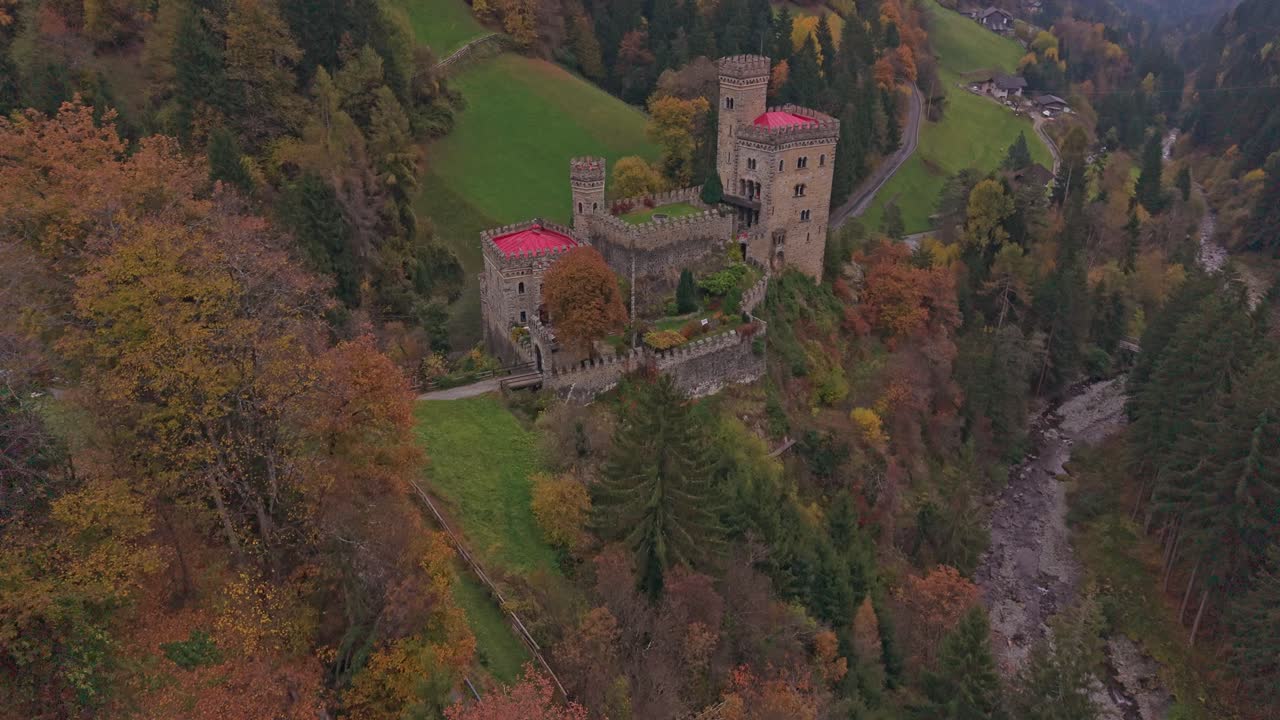 Castello Gerstein circondato da boschi e montagne, vista aerea in autunno