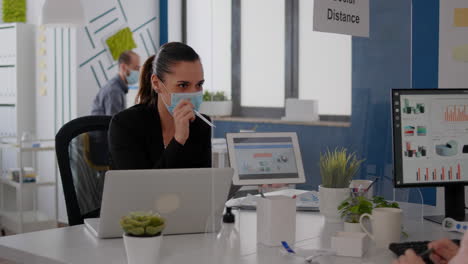 Close-up-of-coworkers-with-face-mask-working-together-at-financial-project