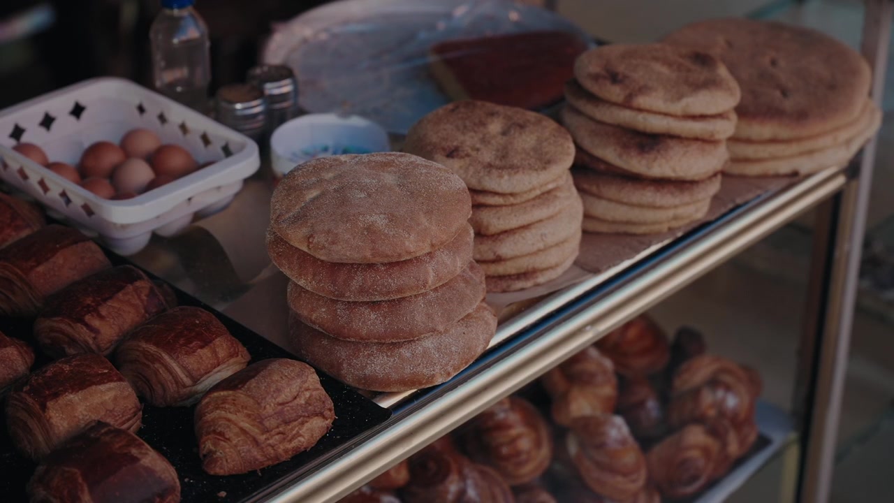Bakeridisk viser stablede flatbrød, croissanter og egg i Marokko.