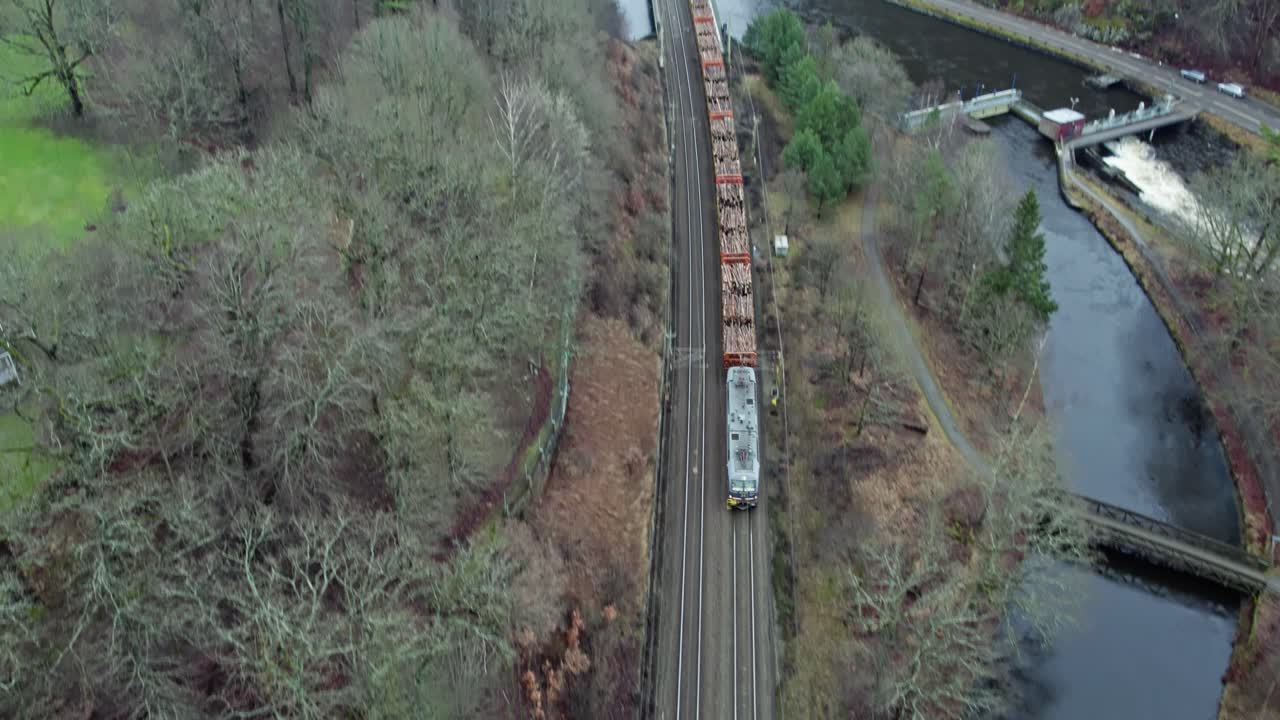 Freight Train Passing Through Jonsered Municipality Along The Lake In Sweden. - aerial shot