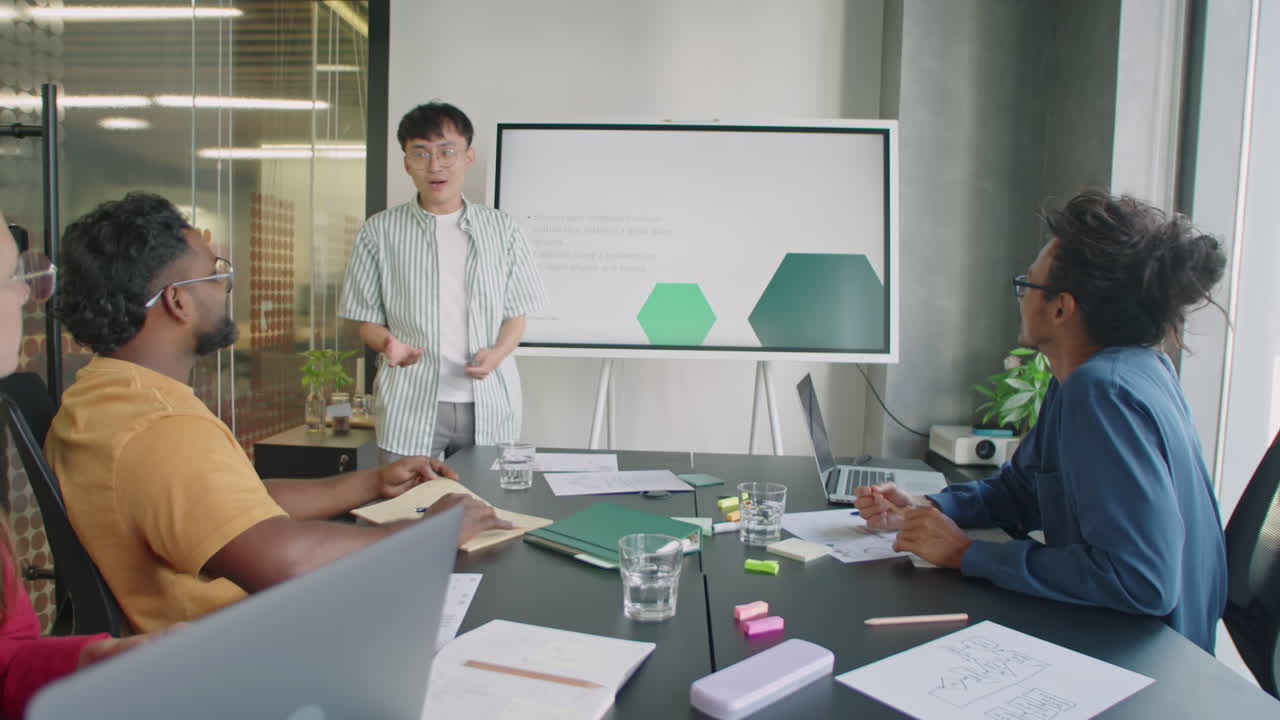 Young Asian Man Giving Presentation on Digital Screen at Meeting