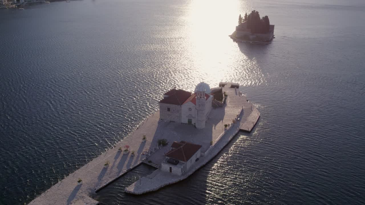 Vista aerea delle isole con chiese nella Baia di Cattaro all'alba a Cattaro, Montenegro, con una splendida illuminazione all'alba, atmosfera calma, riprese drone di alta qualità che catturano momenti sereni.