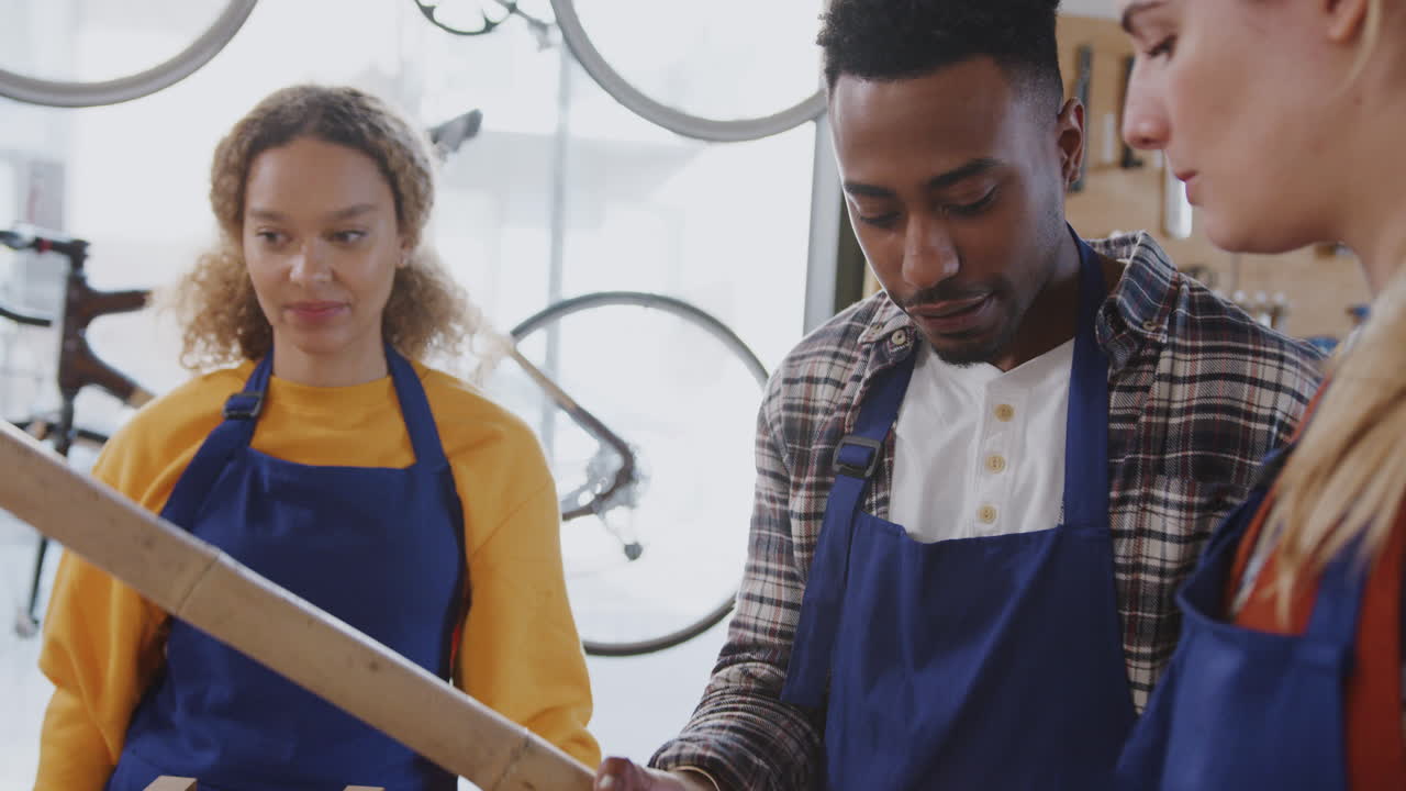 equipo multicultural en el taller de montaje de un marco de bicicleta de bambú sostenible construido a mano