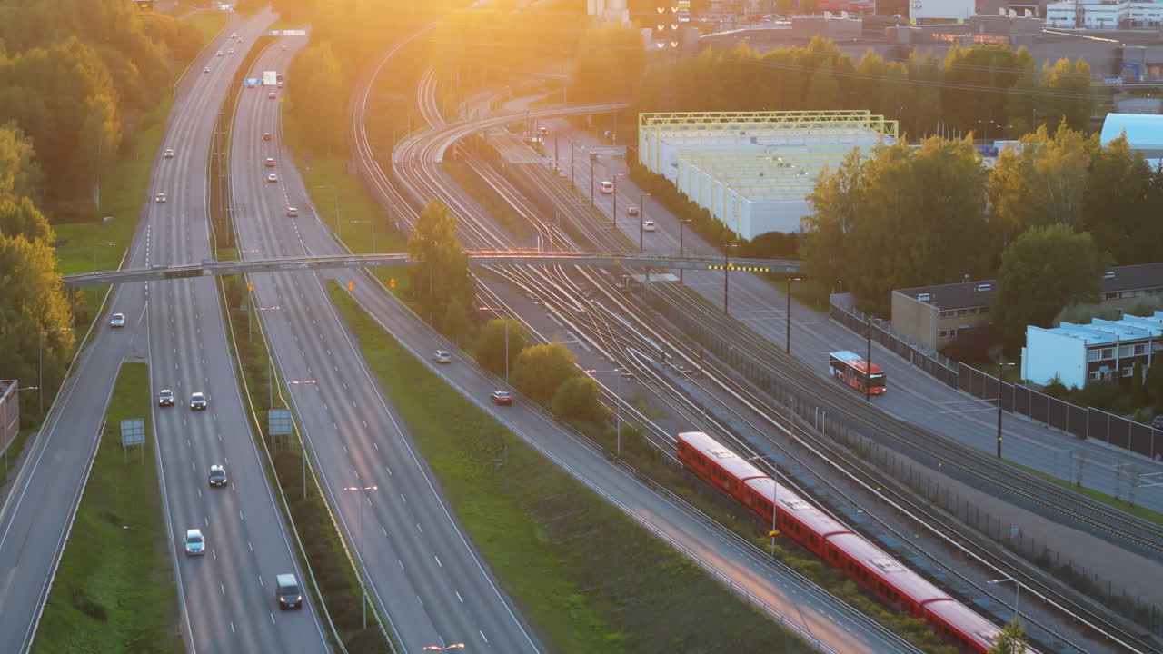 Aerial view of traffic in Helsinki city during sunset. Cars on a highway with exists and public transportation such as busses and under ground train going by