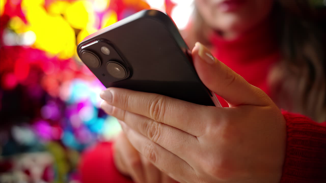 Woman in red sweater working on mobile phone at a restaurant