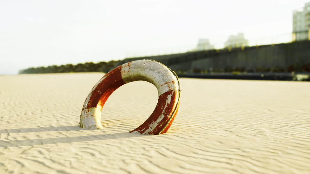 Lifesaver floats on sandy beach in golden light during early morning hours