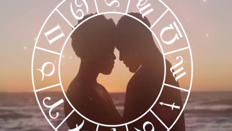 animation of horoscope moving over happy biracial couple embracing at beach