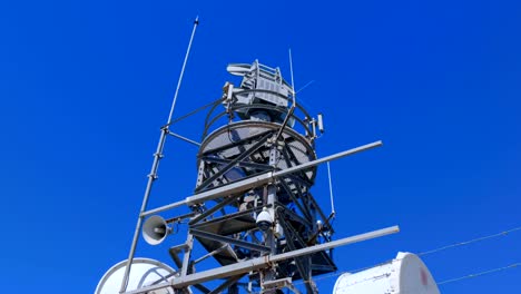 weather radar with a rotating radiodetection antenna on top of a mountain