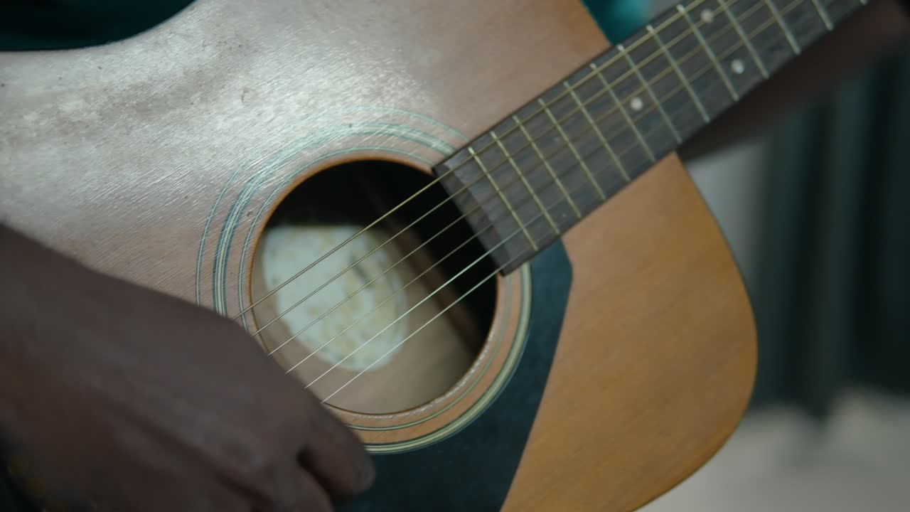 Detail Shot of Young Black Man's Hands Playing an Acoustic Guitar