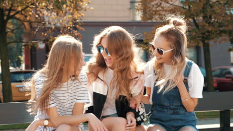 three girls sitting on a bench