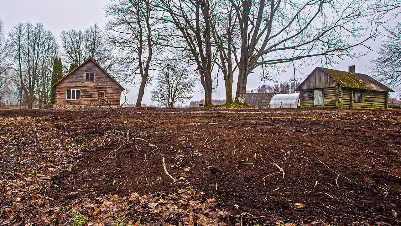 timelapse de un sitio de construcción entre dos casas de madera y árboles
