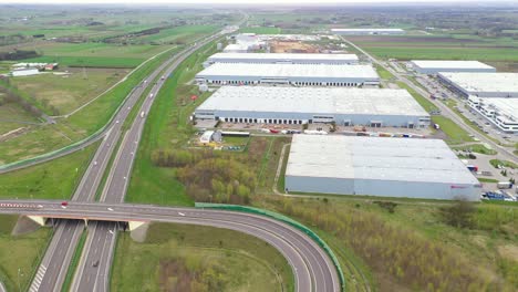 aerial shot of industrial warehouse storage building loading area where many trucks are loading unloading merchandise