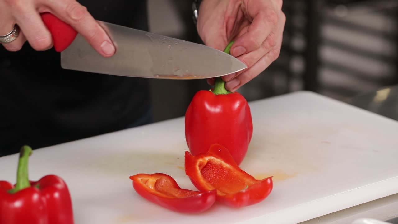 el chef cortando pimientos rojos