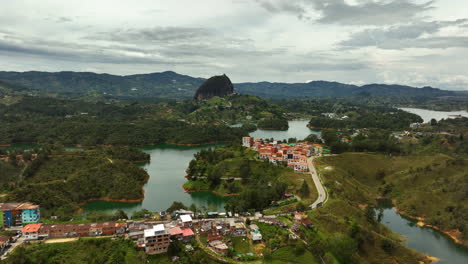 aerial view over a town, toward the monolith rock, in guatape, antioquia, colombia