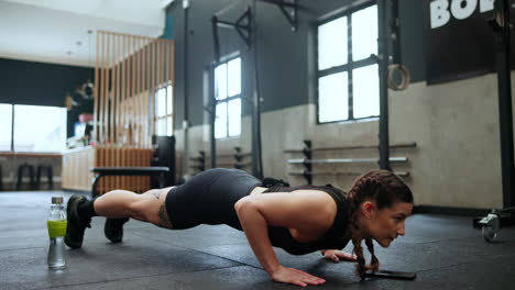 mujer haciendo flexiones en un gimnasio