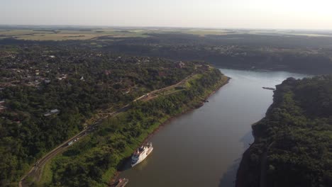 Drohnenaufnahme-Der-Dreifachen-Grenze-Zwischen-Argentinien,-Brasilien-Und-Paraguay-Mit-Kreuzfahrtboot-Am-Parana--Und-Iguazu-fluss