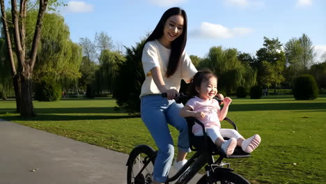 mother and child cycling in a park