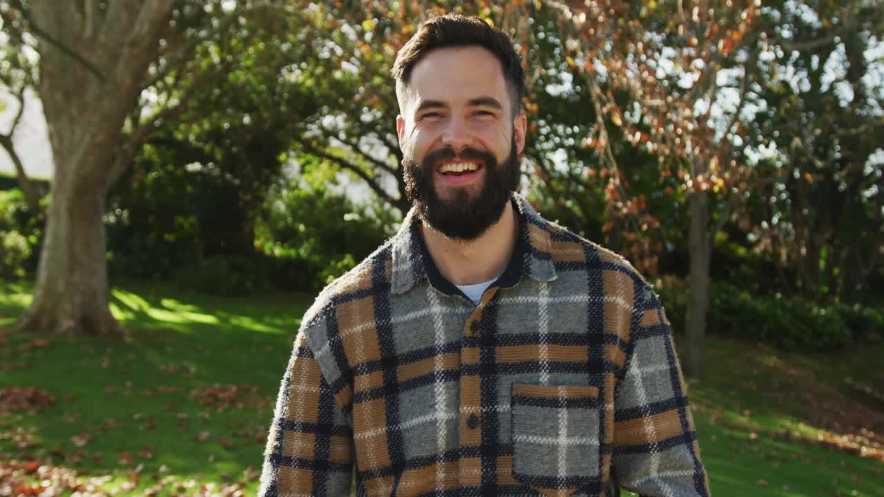 video de hombres caucásicos felices vestidos cálidamente gastando en el jardín