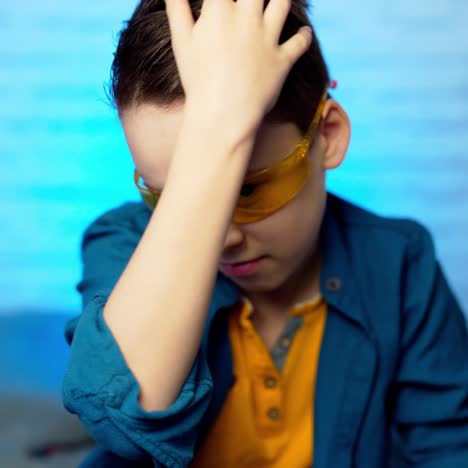 A teen boy putting on medical yellow glasses as a protection against virus disease.