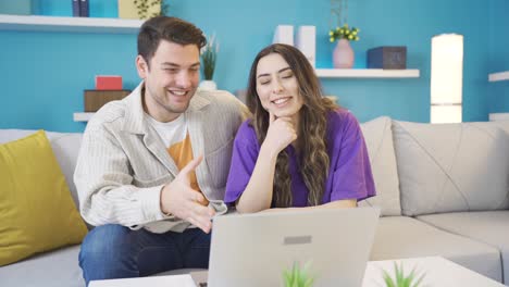 una joven pareja feliz relajándose en el sofá de la sala de estar.