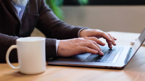 manos de hombre escribiendo en el teclado
