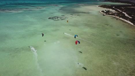 antena de kitesurfistas en el océano azul tropical con playa de arena blanca
