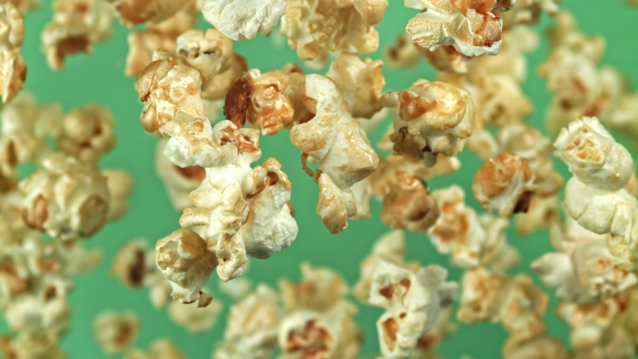 Super rallentatore di popcorn che cadono su sfondo verde