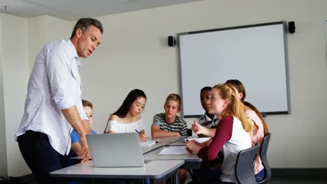 Lehrer-Unterstützt-Schulkinder-Auf-Laptop-4k