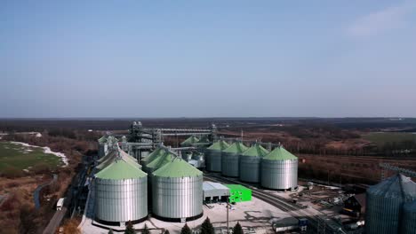 metal silos on field aerial view. large containers for storing and processing grains. silver grain elevators in farmland. storage tank view from above. silo with grain.