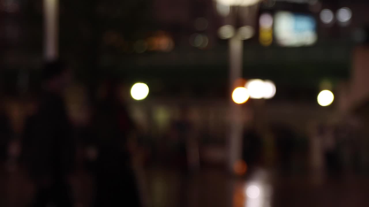 비가 오는 날 밤 신주쿠의 거리에서 걸어다니는 사람들이 손에 들고 있습니다.