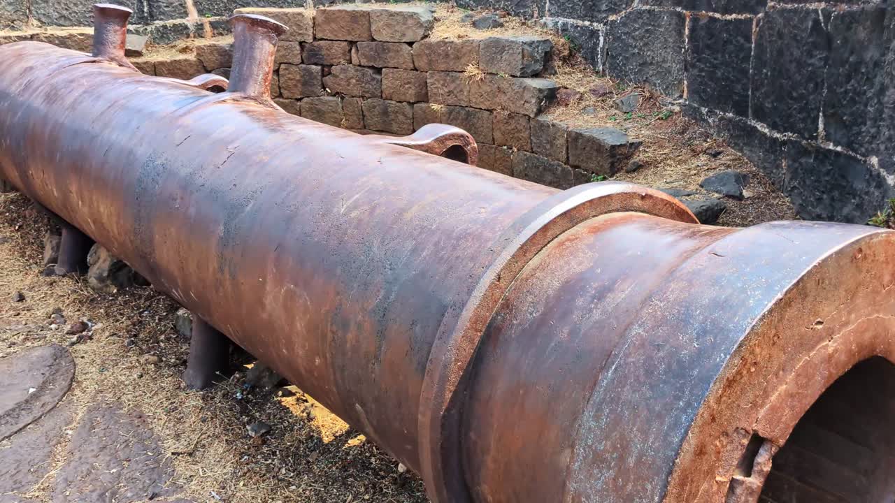 Vecchio cannone nel forte di Bidar, pieno di pietre, e muro in pietra a Karnataka, India. Di giorno, ripresa all'indietro, ripresa a mano libera, 4K