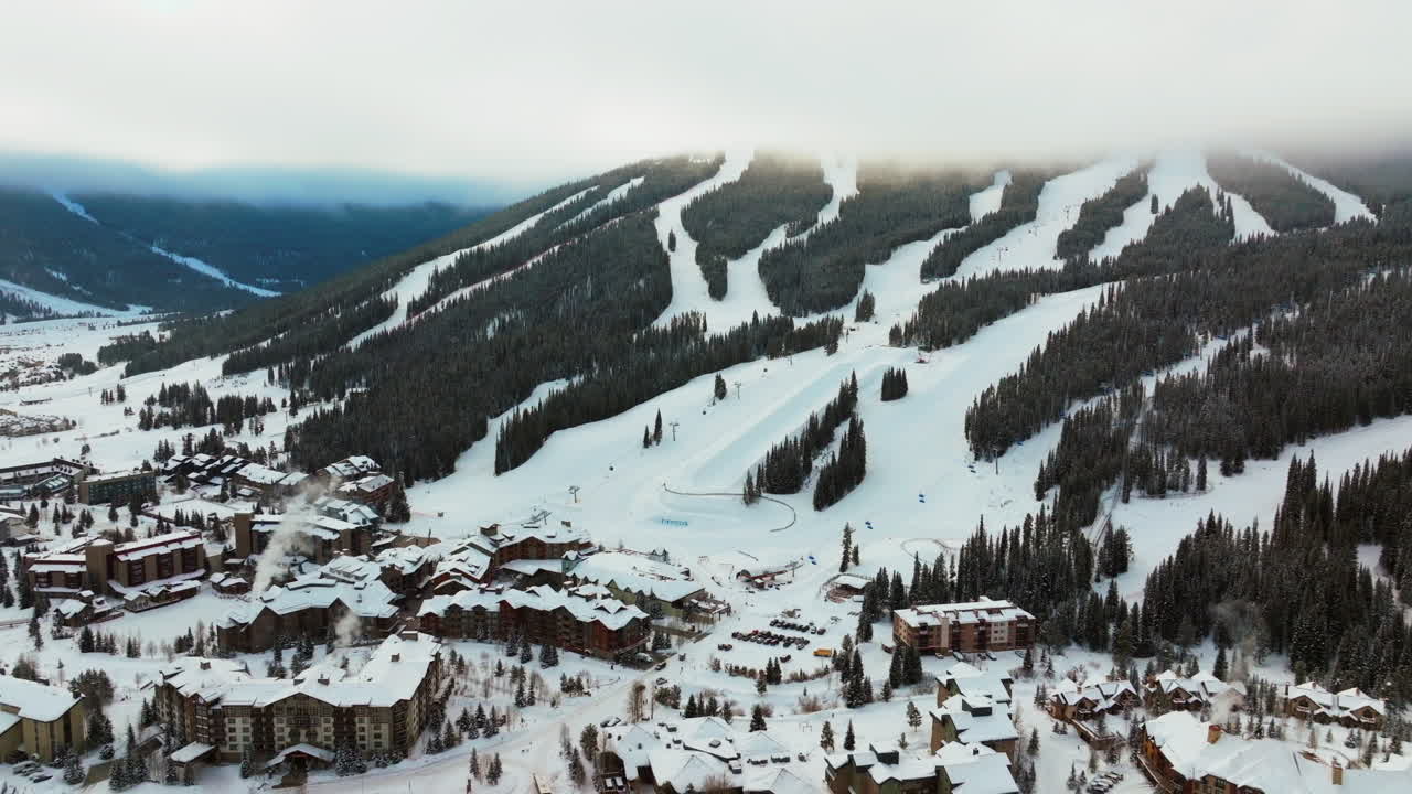 montaña de cobre capa de nubes de niebla invierno nevado temprano en la mañana amanecer dron aéreo colorado estación de esquí i70 águila volador ascensor centro pueblo media tubería icono paso épico snowboarding hacia atrás lentamente revelar