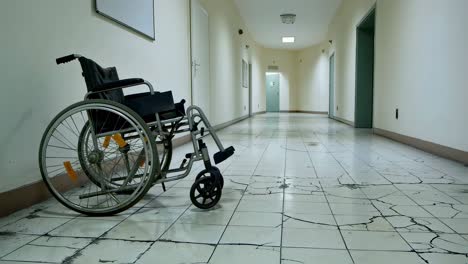 empty wheelchair is standing in a desolate hospital corridor with cracked floor tiles, symbolizing abandonment and decline