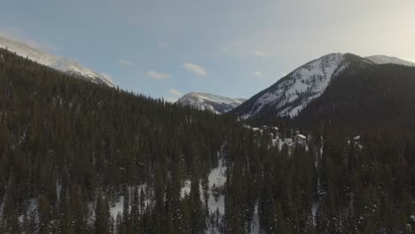 flying through light snow in snow covered mountain valley