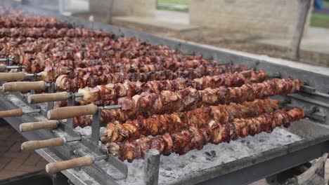 Deliciosa-Carne-De-Cerdo-Y-Pollo-A-La-Barbacoa-Girando-Sobre-Un-Asador-Sobre-Brasas