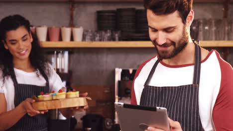 camarero usando una tableta digital en la cafetería