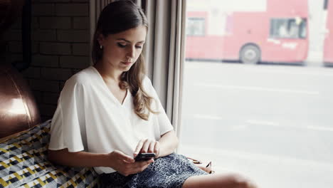 Attractive-business-woman-sexy-legs-using-mobile-smart-phone-cafe-city-commuters-in-background