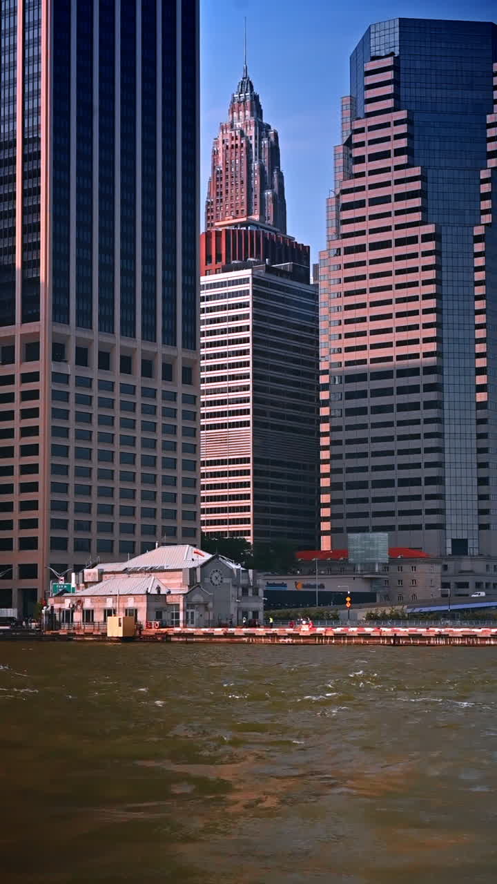 Arranha-céus de vidro modernos refletindo a luz solar em Nova York. Arranha-céus do centro de Nova York refletindo a luz solar quente nas fachadas de vidro ao longo do horizonte à beira-mar