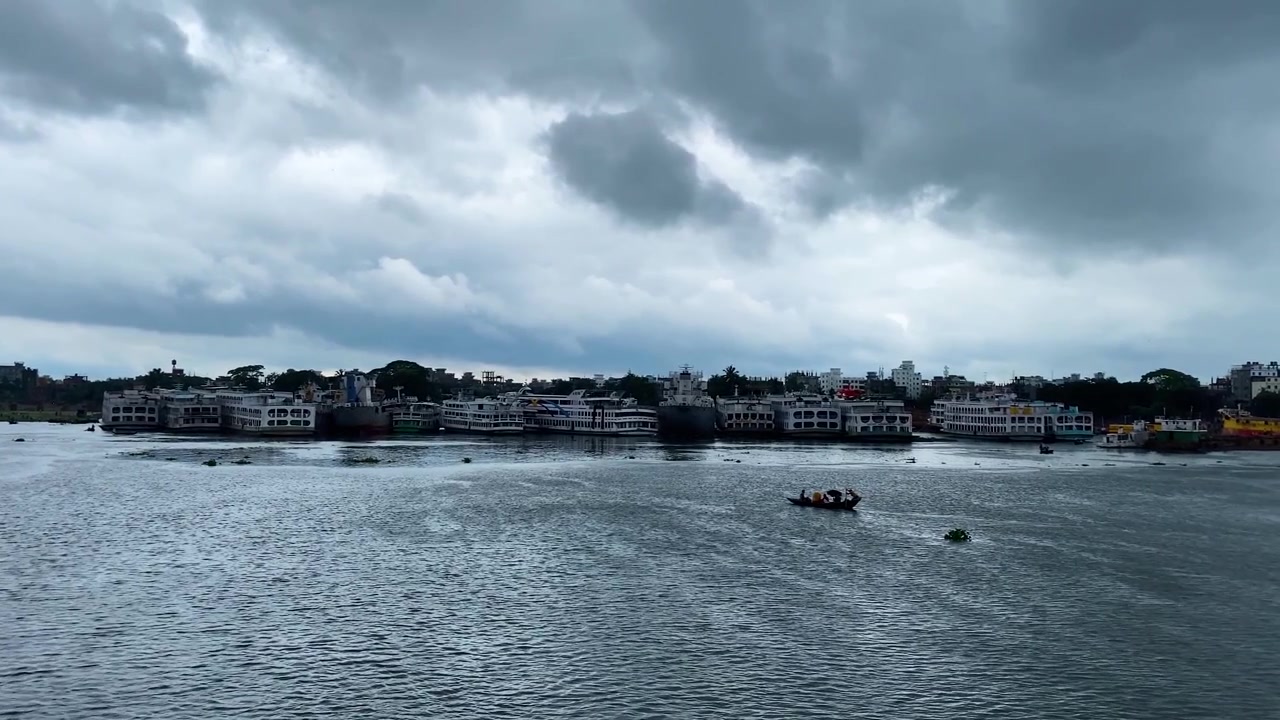 Navi passeggeri a Sadarghat sul fiume Buriganga sotto un cielo tempestoso durante il monsone in Bangladesh - scatto grandangolare.