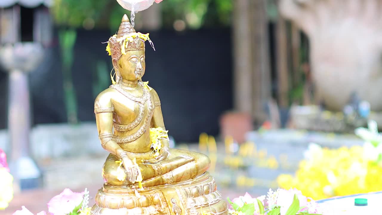 Pouring water over Buddha statue in ritual