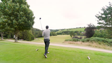 male golf player playing golf, hitting the ball with club on a golf course, copy space