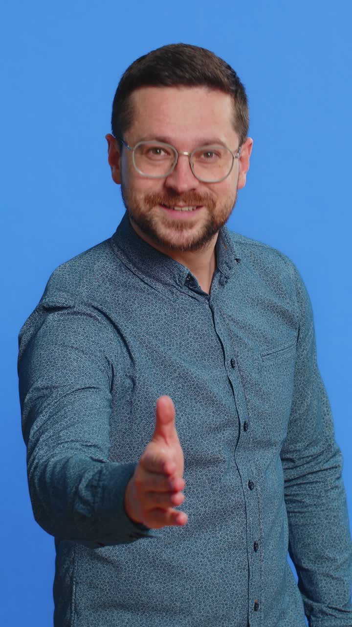hombre caucásico extendiendo la mano a la cámara ofreciendo un apretón de manos saludando invitación de bienvenida